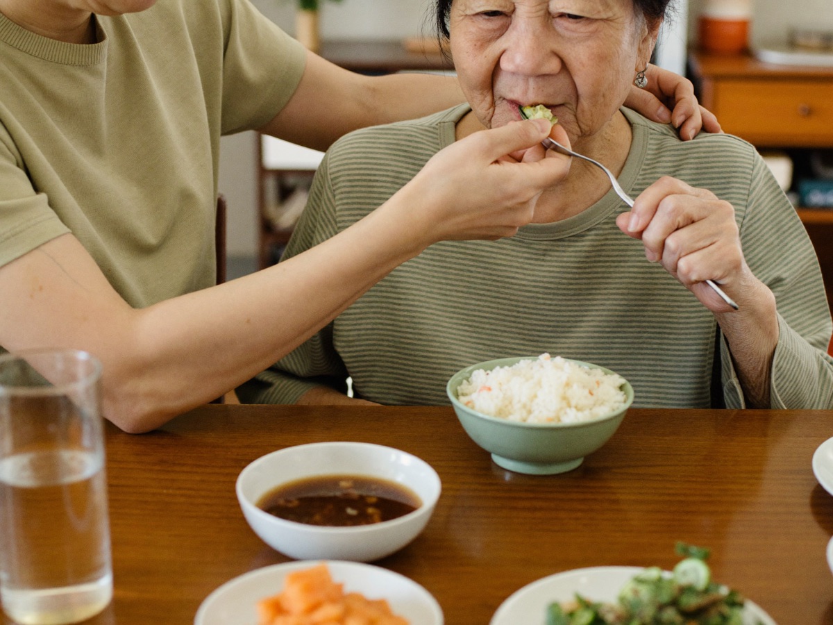 요양보호사가 어르신의 식사를 돕는 모습